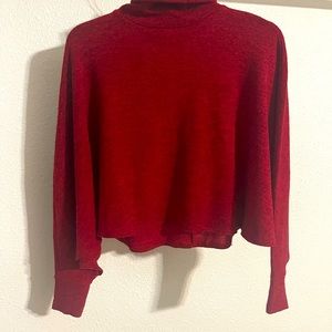 Blusa roja, cuello alto tipo capa.